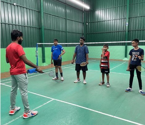 A coach leading a junior badminton session